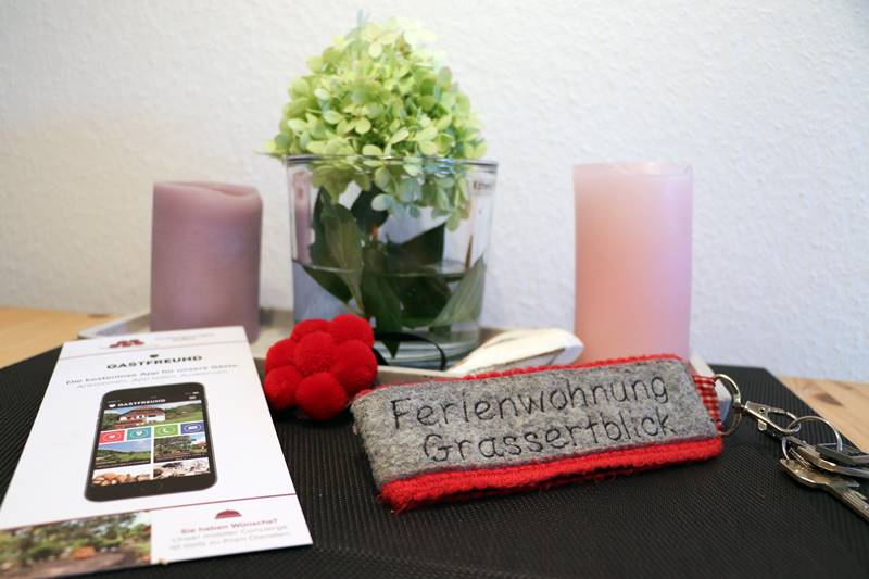 Schlüssel zur Ferienwohnung Grassertblick liegt auf Esstisch, mit Schwarzwalddeko und Infoblatt zur Gastfreund-App