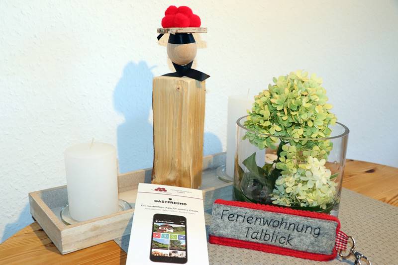 Schlüssel zur Ferienwohnung Talblick liegt auf Esstisch mit Schwarzwaldeko und Infoblatt zur Gastfreund-App