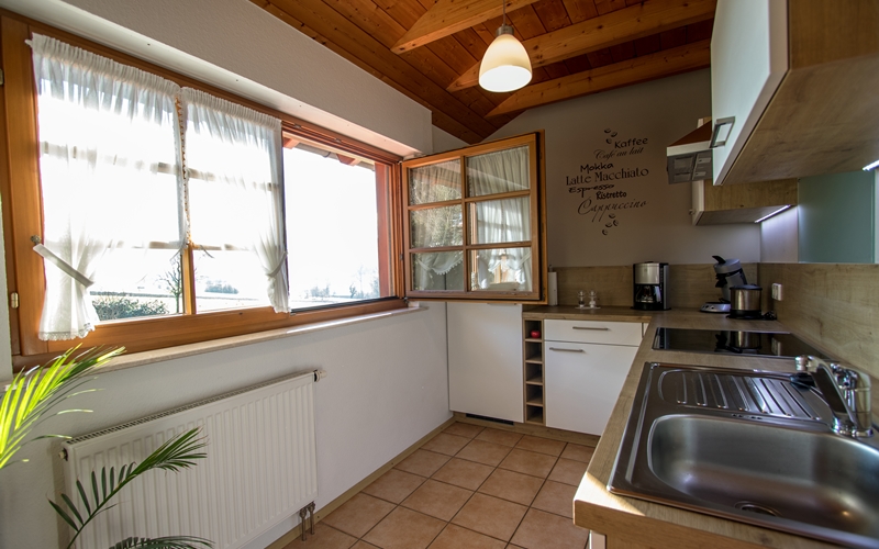 Küche der Ferienwohnung Waldblick mit Wandtatoo und großem Fenster mit Blick in den Garten und in das Schuttertal